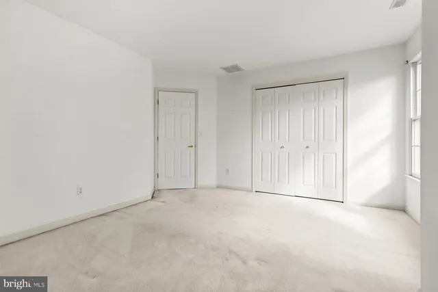 a white house that has a small yard and large trees