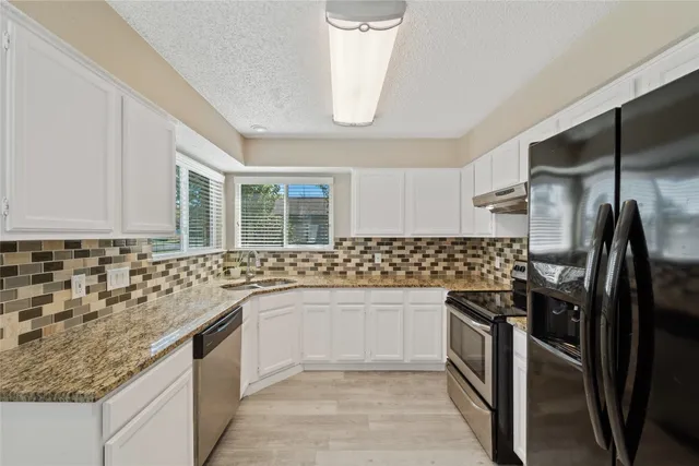 a kitchen with a refrigerator stove and cabinets