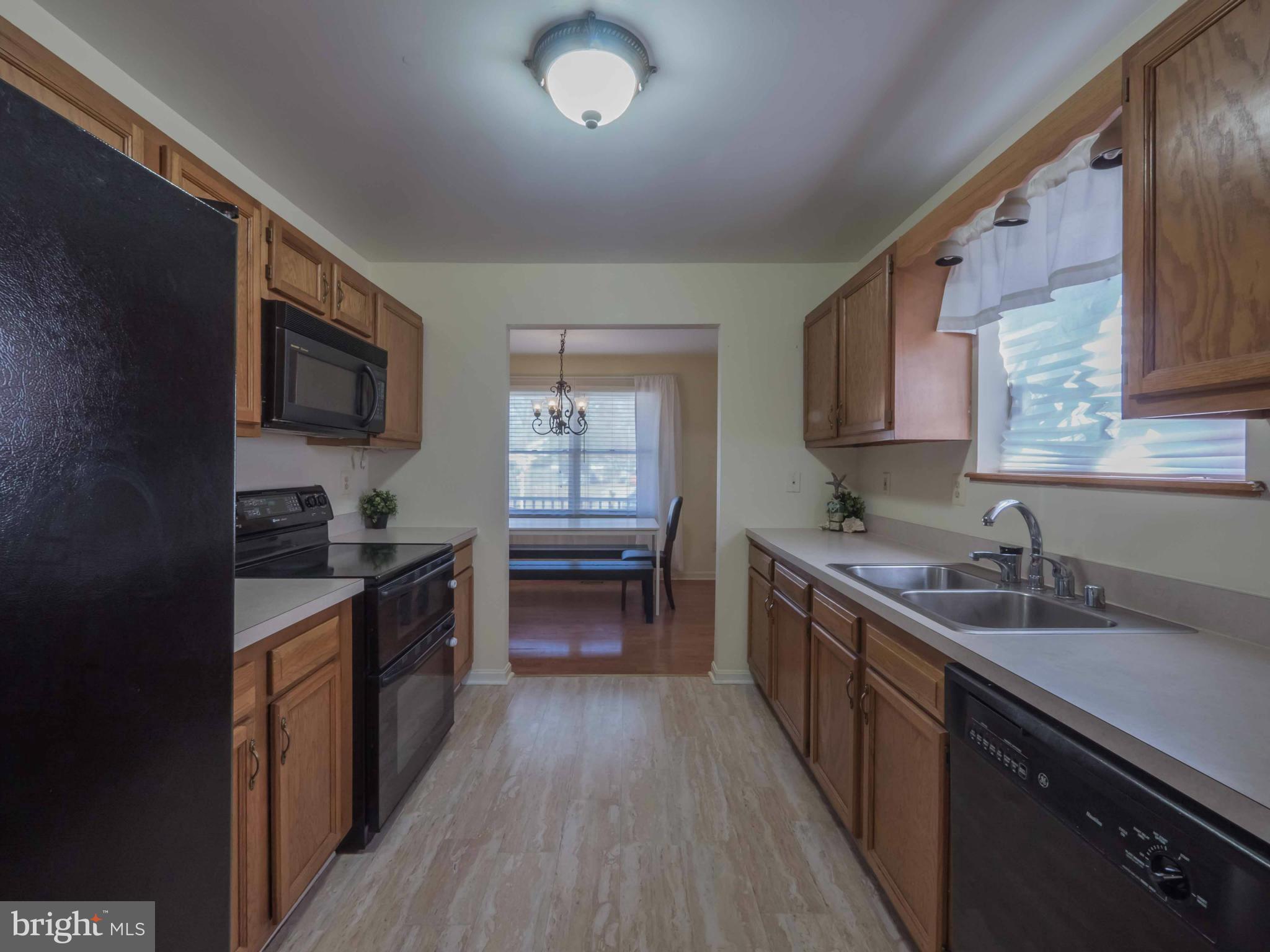 413 Salisbury Road Edgewater, MD 21037 - Photo 4 of 30 a kitchen with granite countertop a sink wooden floor and stainless steel appliances