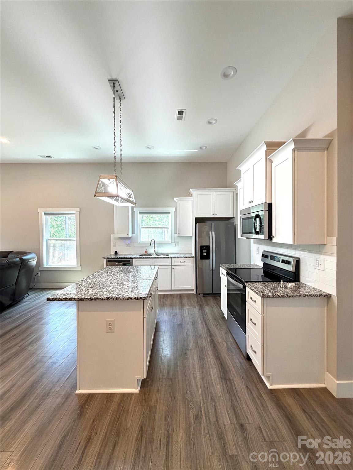 1473 Pleasant School Road Gaffney, SC 29341 - Photo 9 of 16 a kitchen with stainless steel appliances kitchen island granite countertop wooden floors and sink
