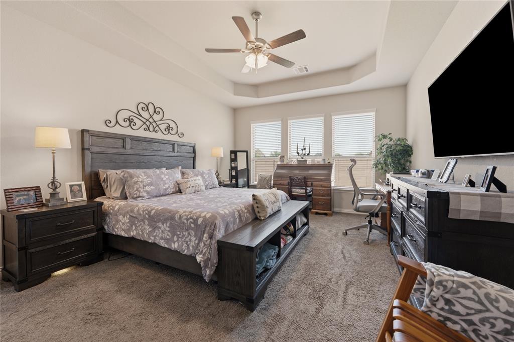 140 Chestnut Road Waxahachie, TX 75165 - Photo 17 of 26 Spacious carpeted room featuring a tray ceiling with a ceiling fan, a series of three large windows, and ample wall space