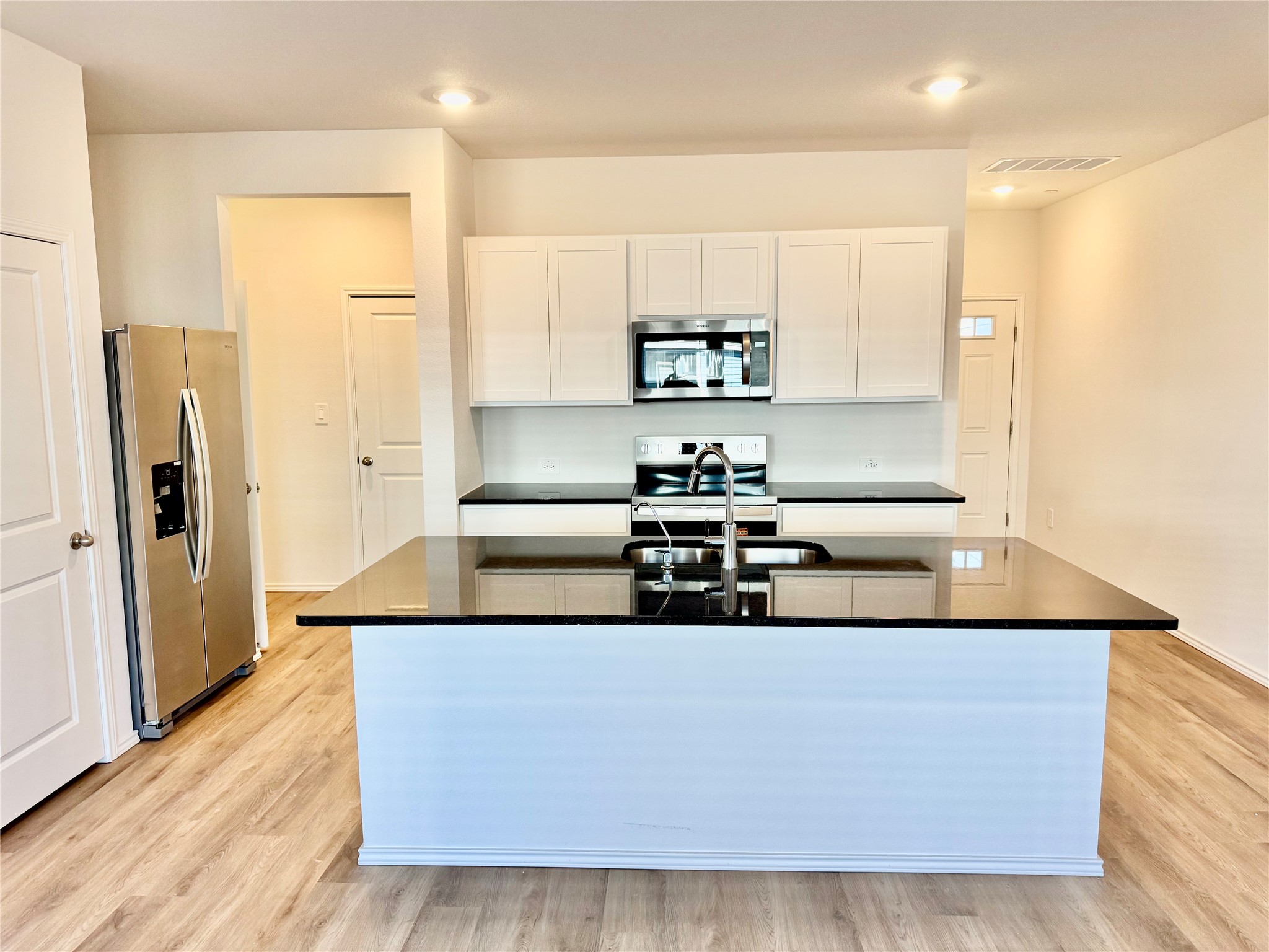 105 Calcite Road, Unit 3 Kyle, TX 78640 - Photo 2 of 7 a kitchen with stainless steel appliances granite countertop a sink and a refrigerator