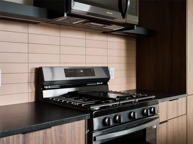 a kitchen with kitchen island granite countertop a sink stainless steel appliances and cabinets