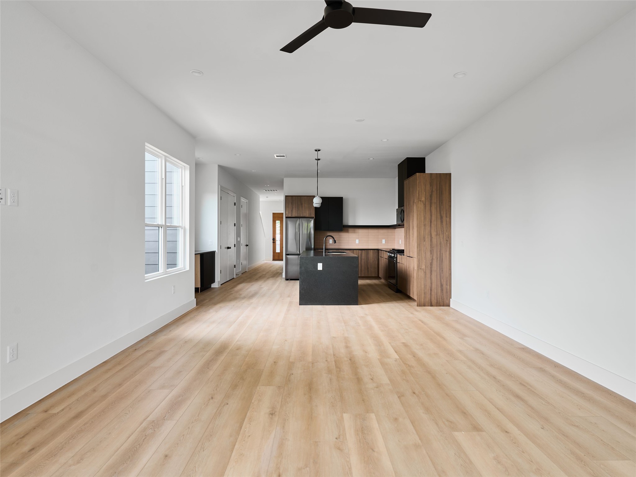 412 Hackberry Lane, Unit 2 Austin, TX 78753 - Photo 39 of 40 Kitchen with open floor plan, an island with sink, decorative light fixtures, freestanding refrigerator, and a ceiling fan