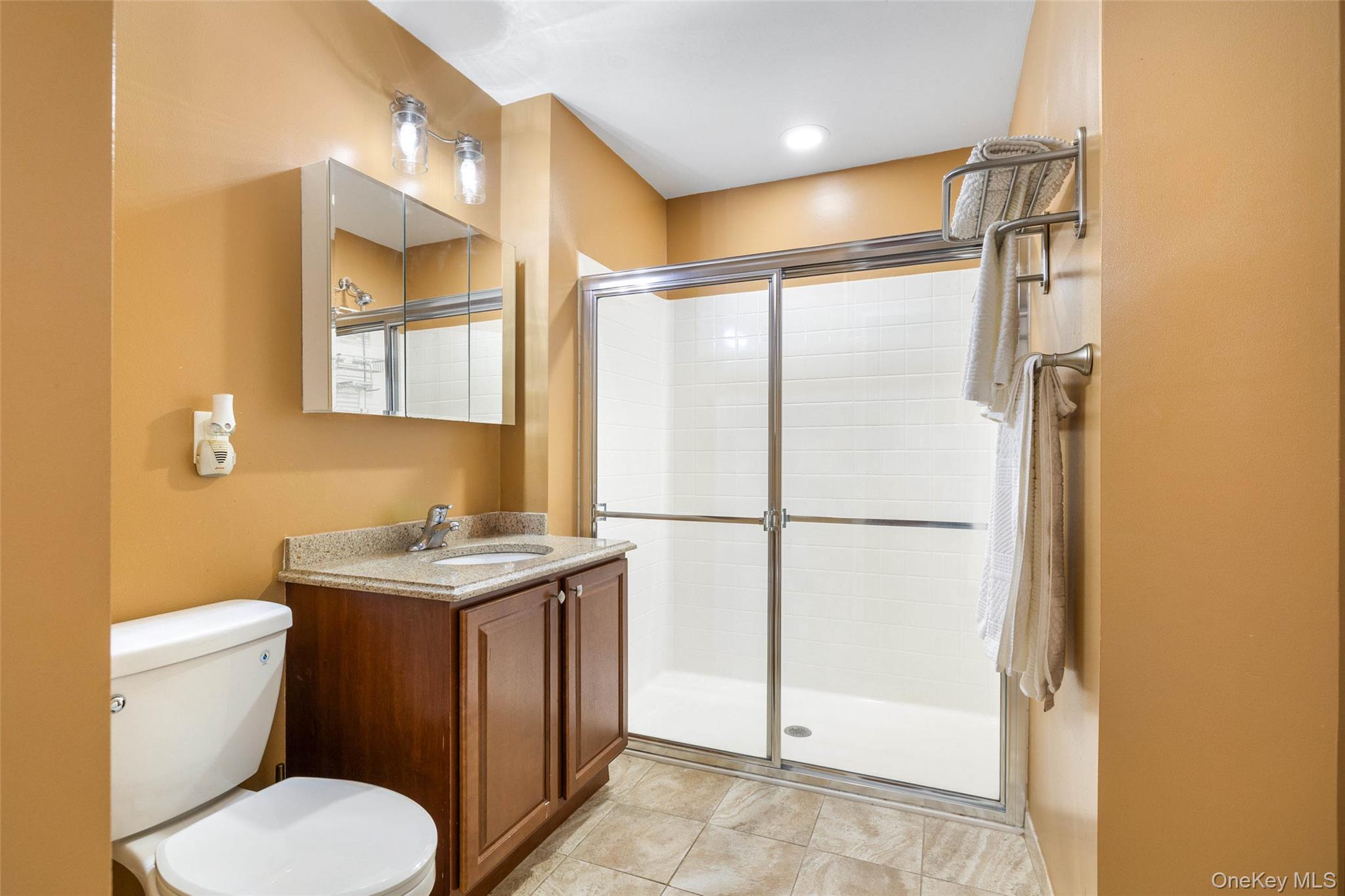 121 Willow Lane Valley Stream, NY 11580 - Photo 17 of 30 Full bathroom featuring a stall shower, vanity, and light tile patterned flooring