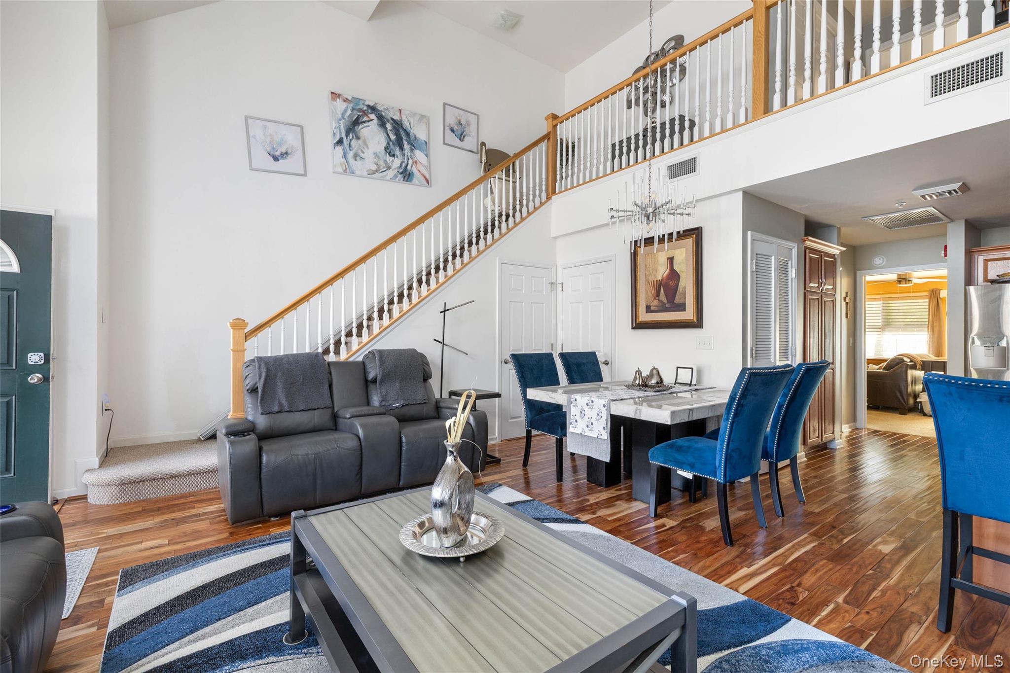 121 Willow Lane Valley Stream, NY 11580 - Photo 5 of 30 Living room with a towering ceiling, wood finished floors, a chandelier, and stairway