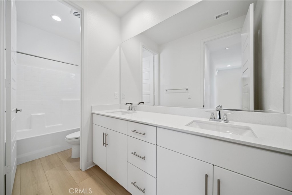 187 Yugen Irvine, CA 92618 - Photo 18 of 31 a bathroom with a double vanity sink and mirror with toilet