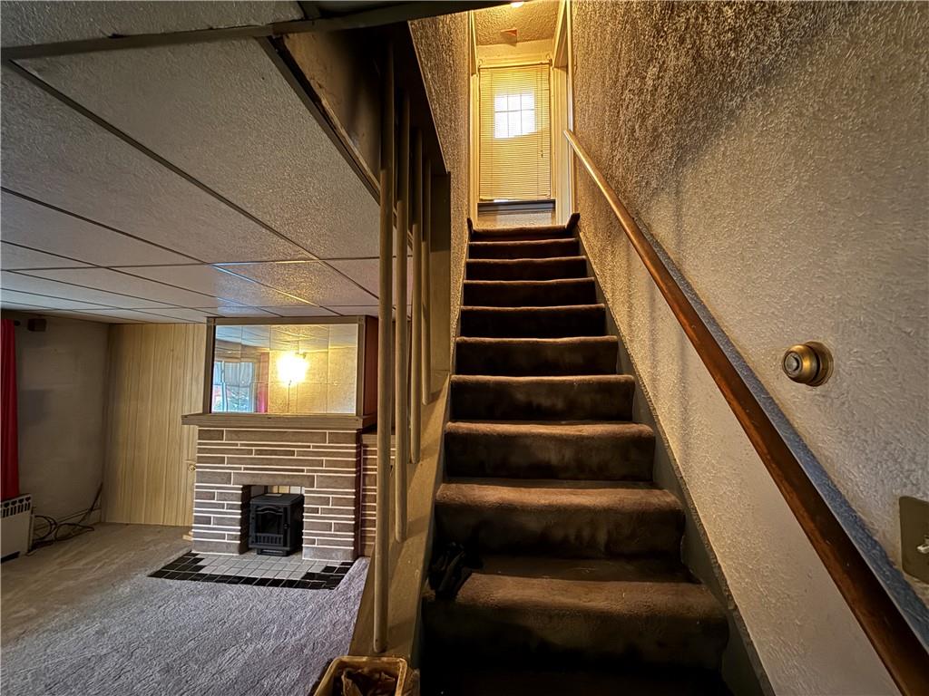 727 Thompson Street Turtle Creek, PA 15145 - Photo 6 of 25 a view of staircase with wooden floor and a fireplace