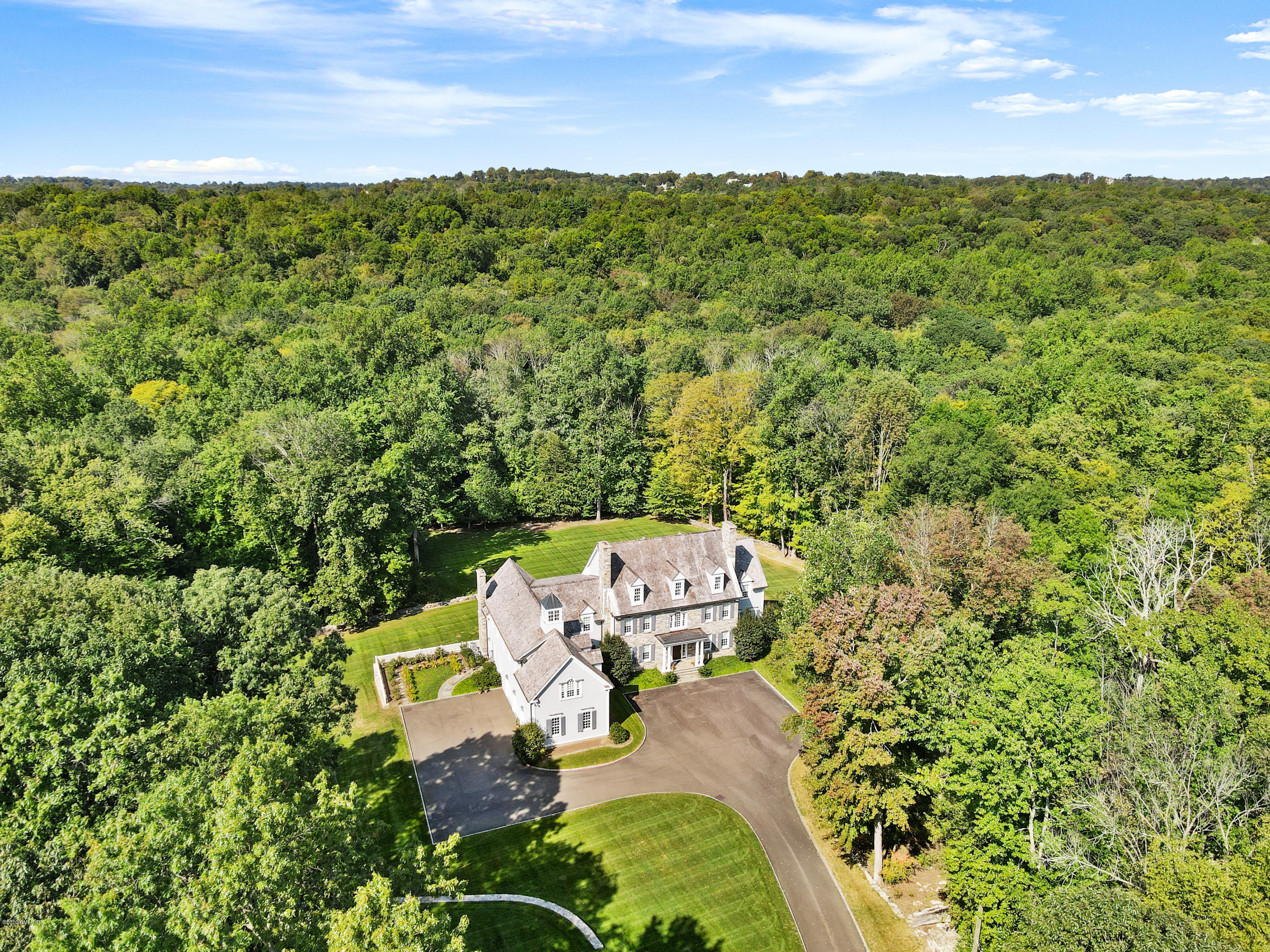 an aerial view of a house with garden space and outdoor seating