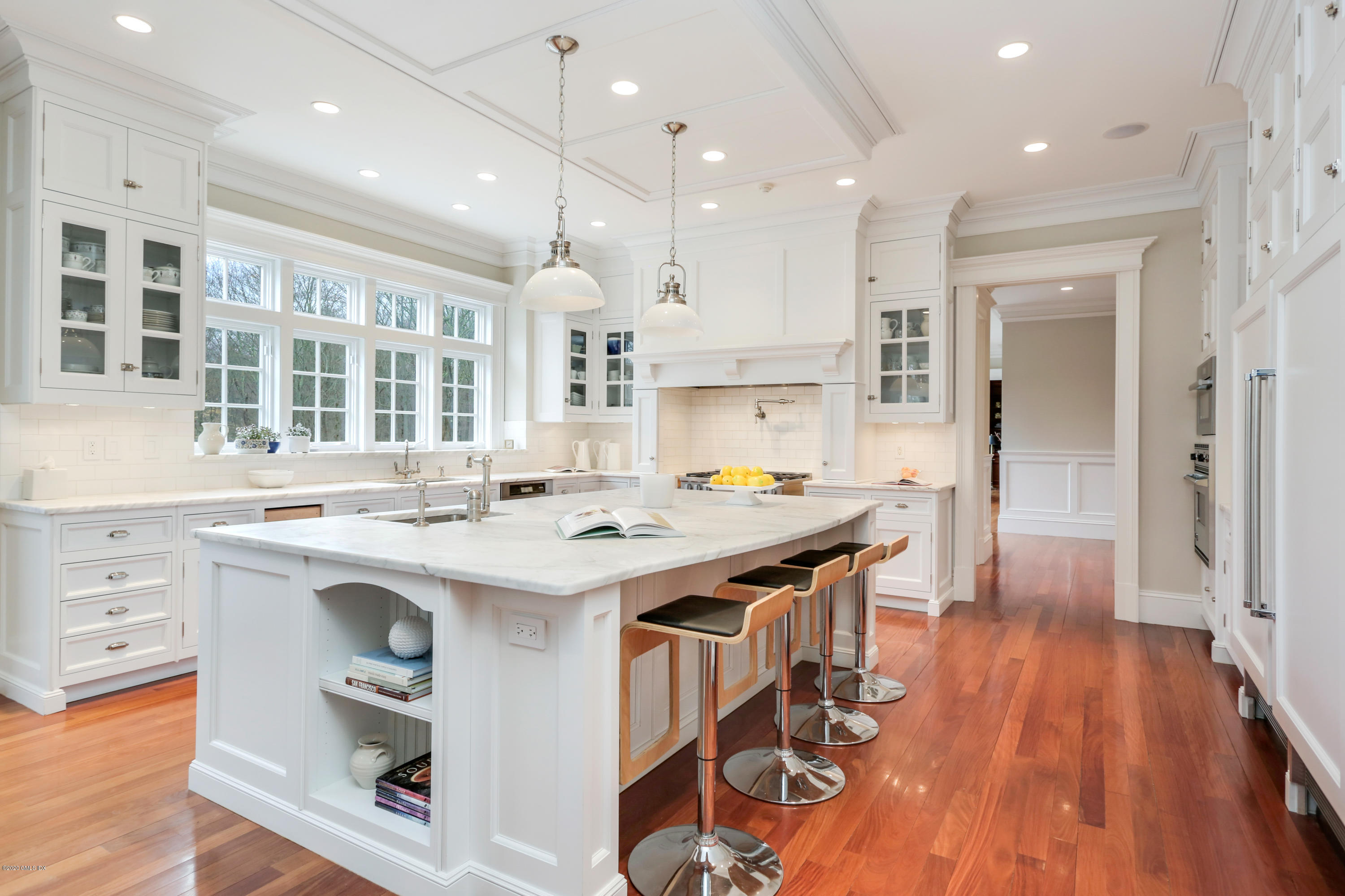70 Old Mill Road Greenwich, CT 06831 - Photo 9 of 20 a kitchen with kitchen island a stove a sink a refrigerator and a dining table with wooden floor