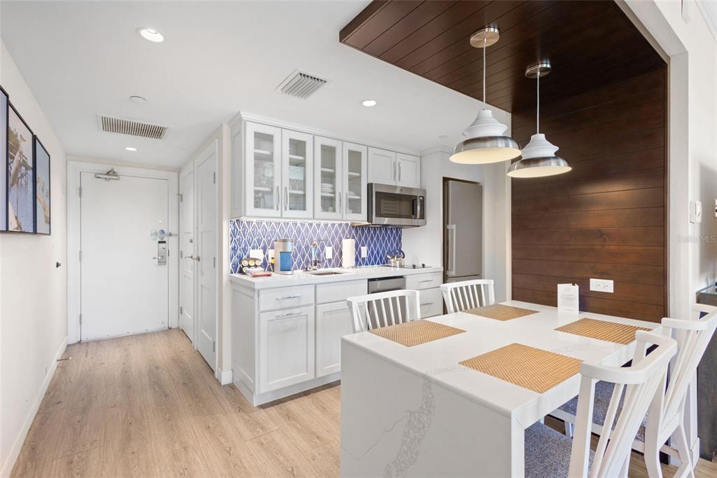 240 Sands Point Road, Unit 4104 Longboat Key, FL 34228 - Photo 13 of 47 a kitchen that has a lot of cabinets in it and wooden floor