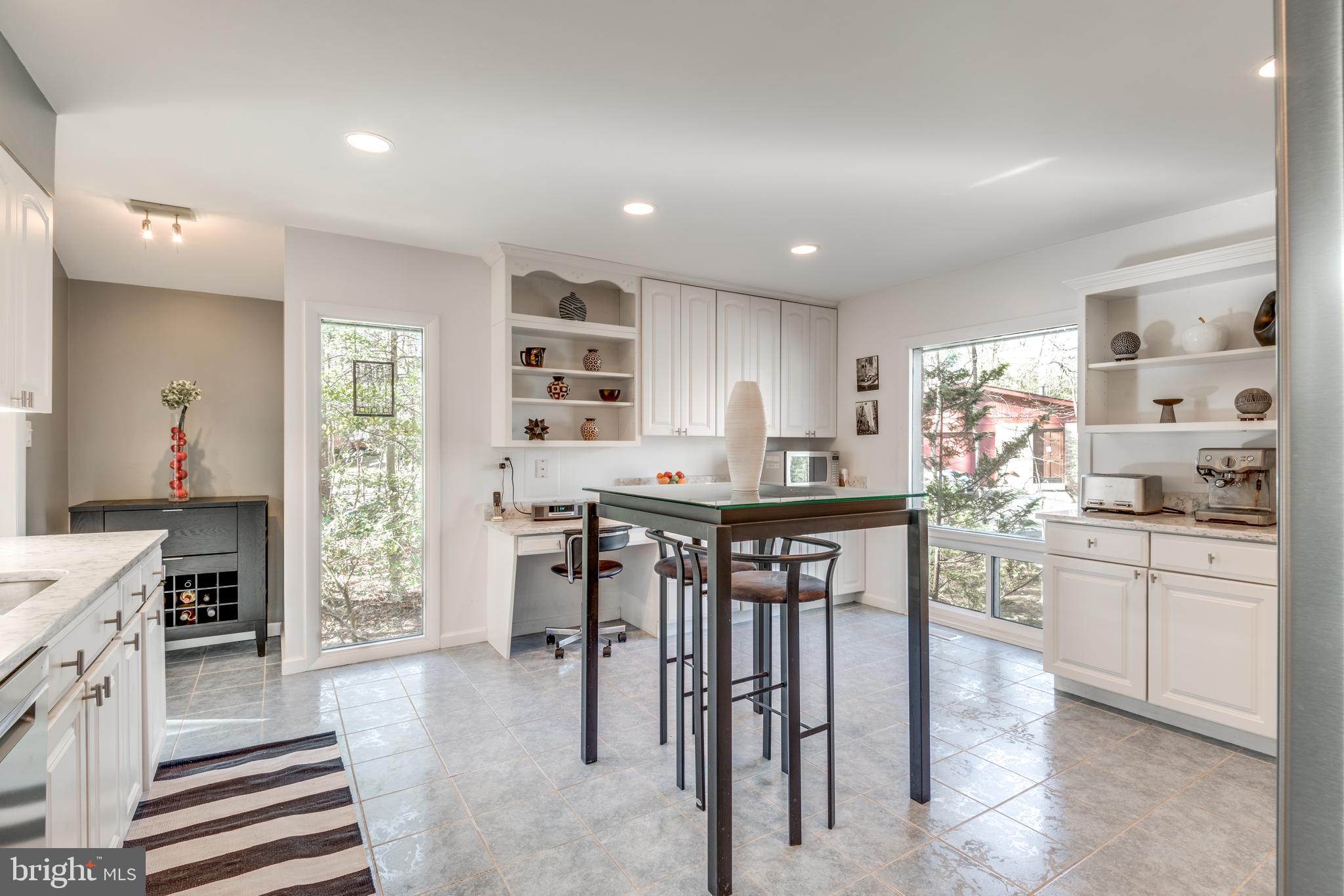 11401 Drop Forge Lane Reston, VA 20191 - Photo 13 of 38 a kitchen with stainless steel appliances kitchen island granite countertop a table chairs sink and cabinets