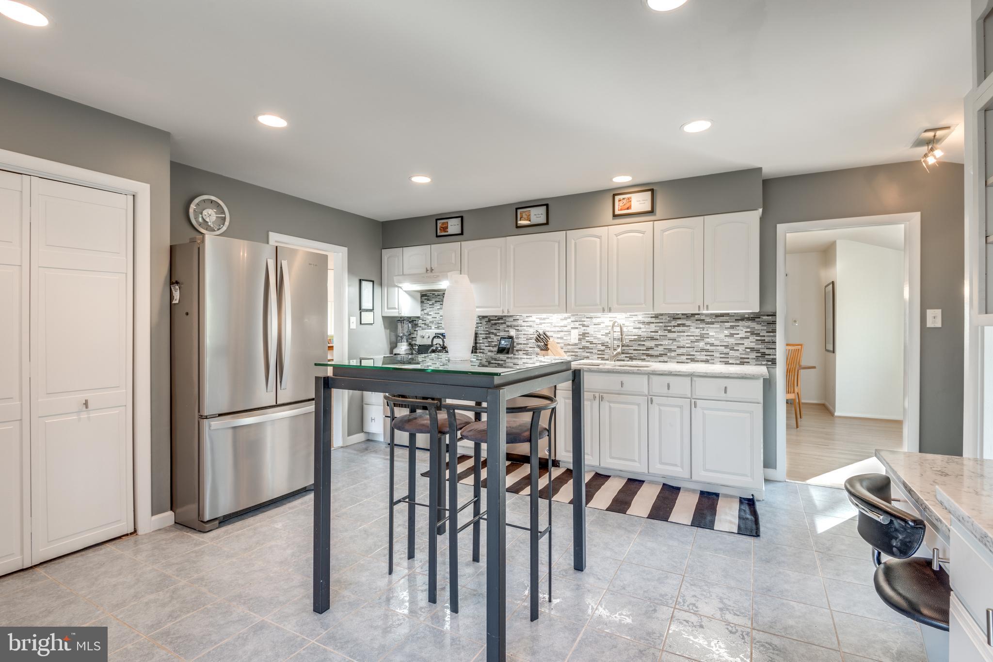 11401 Drop Forge Lane Reston, VA 20191 - Photo 15 of 38 a kitchen with a refrigerator and white cabinets