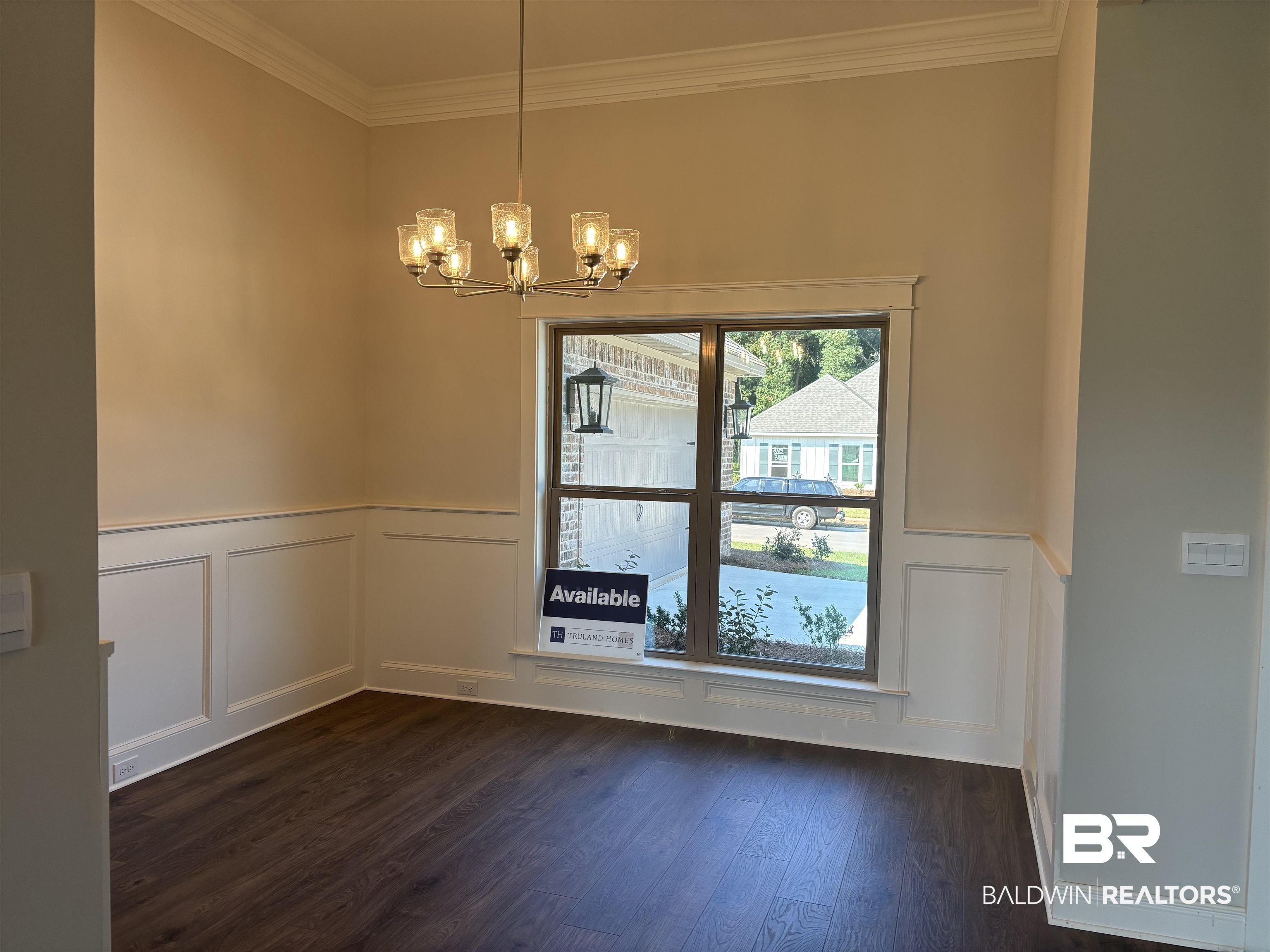 388 Garrison Boulevard Fairhope, AL 36532 - Photo 6 of 34 Spare room featuring dark hardwood / wood-style floors, crown molding, and a notable chandelier
