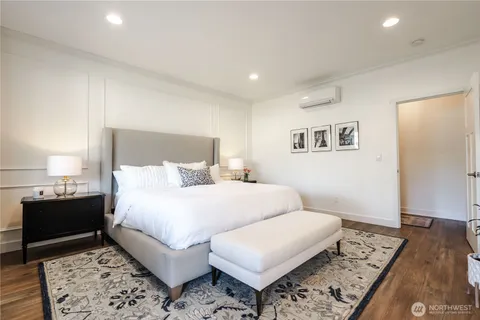 a bedroom with a large bed and wooden floor