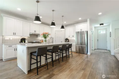 a kitchen with kitchen island a sink appliances and cabinets