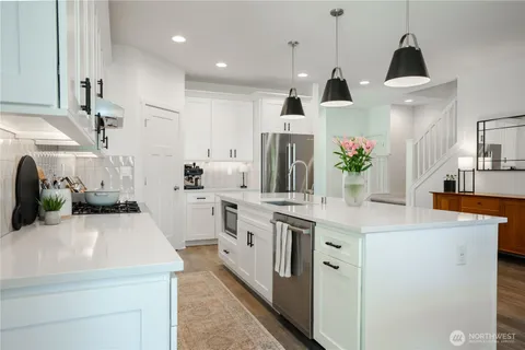 a kitchen with white cabinets and appliances