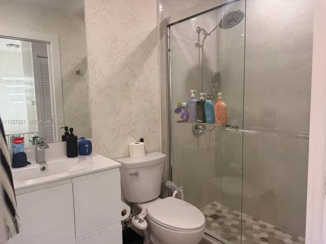 a bathroom with a toilet sink vanity and shower