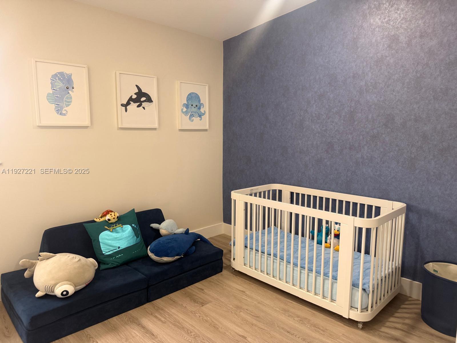 6864 Northwest 166th Terrace, Unit 903 Miami Lakes, FL 33014 - Photo 26 of 29 a bedroom with furniture and a wooden floor