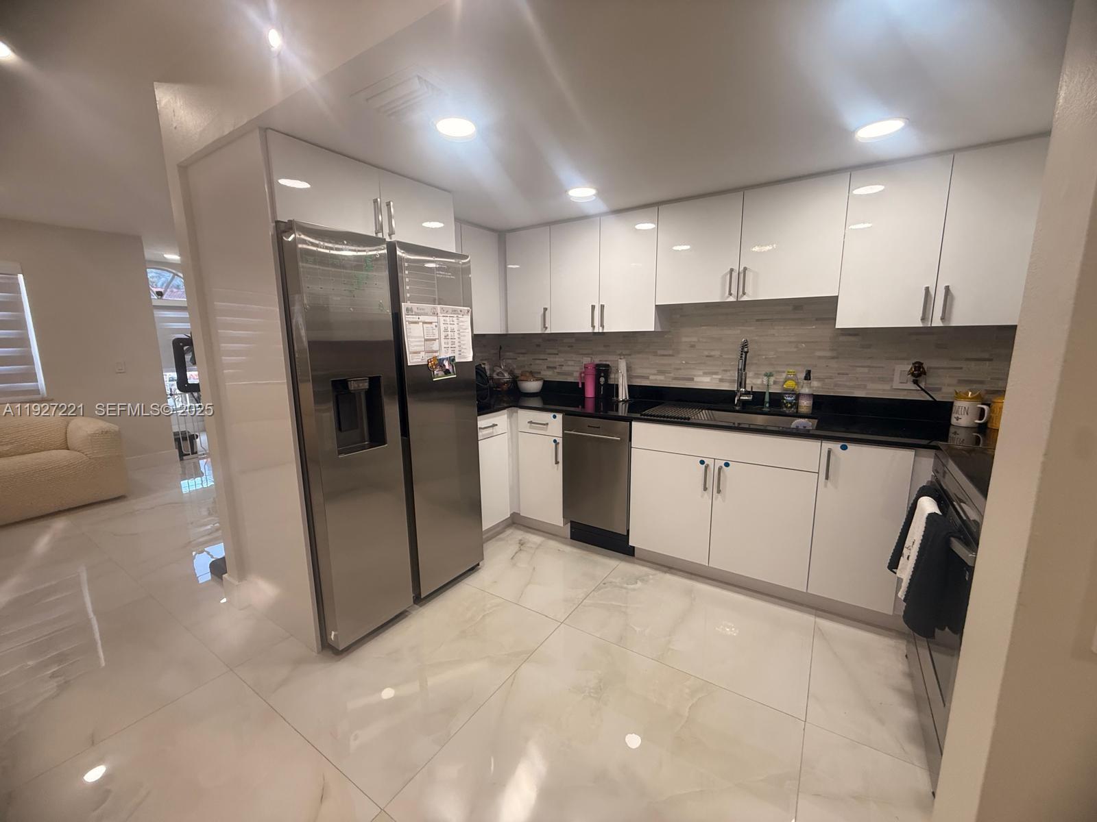 6864 Northwest 166th Terrace, Unit 903 Miami Lakes, FL 33014 - Photo 5 of 29 a kitchen with stainless steel appliances granite countertop a sink a stove a refrigerator and cabinets