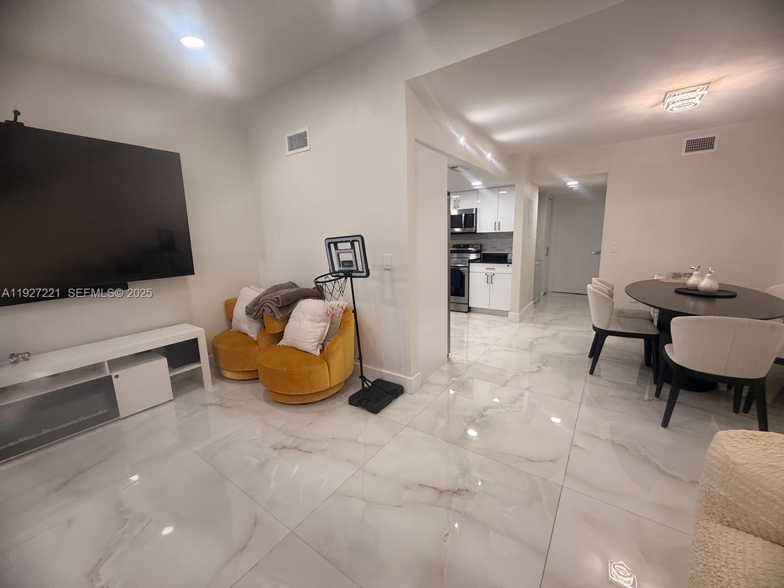6864 Northwest 166th Terrace, Unit 903 Miami Lakes, FL 33014 - Photo 6 of 29 a room with furniture and a flat screen tv