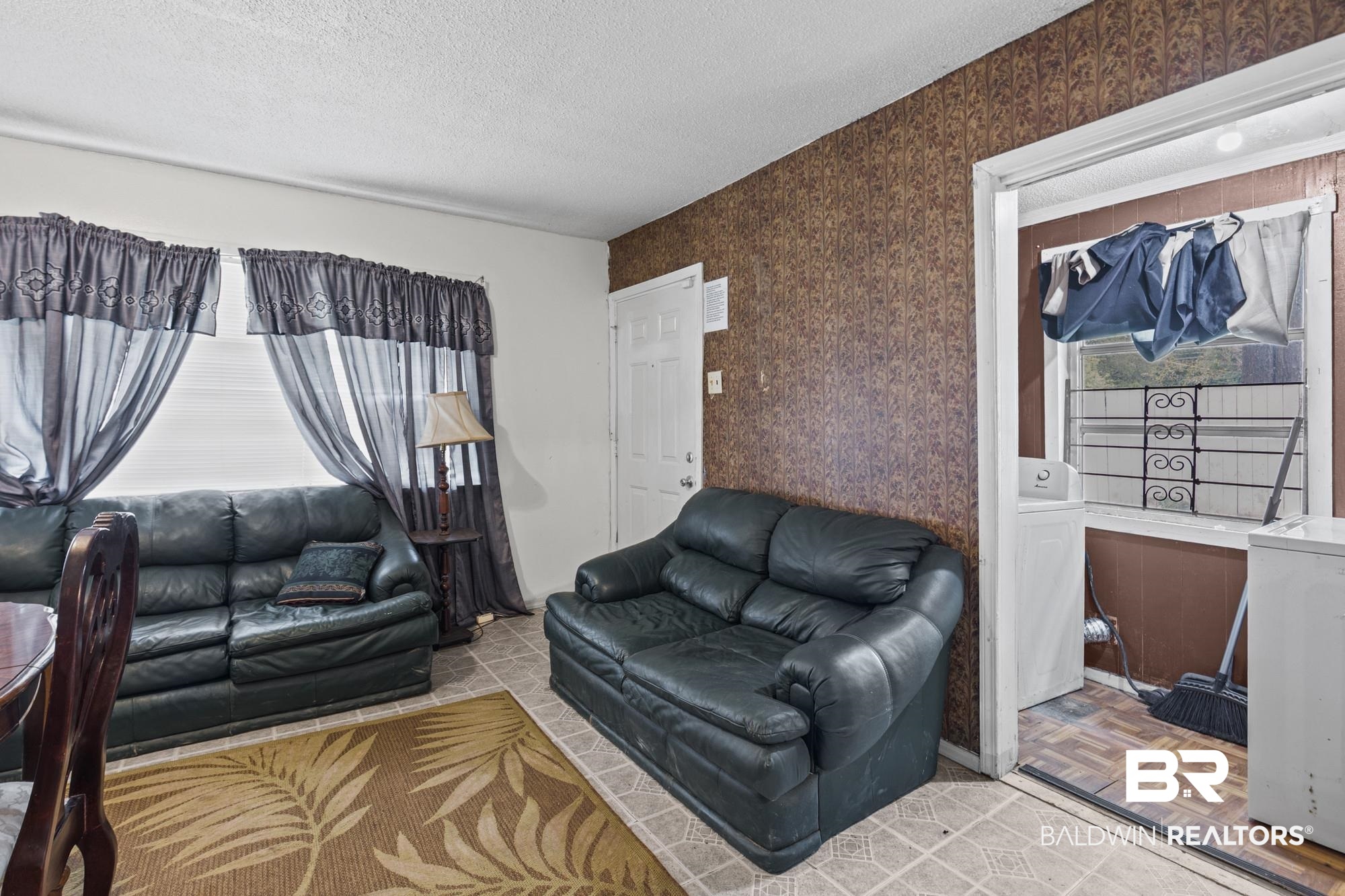 160 Glenn Avenue Mobile, AL 36606 - Photo 6 of 15 Living area featuring light-toned tile flooring and a textured accent wall