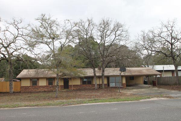 6047 Eden Square Crestview, FL 32539 - Photo 2 of 39 a view of a white house next to a road with large trees