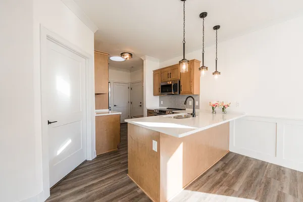 a kitchen with stainless steel appliances granite countertop a sink a stove and a wooden floors