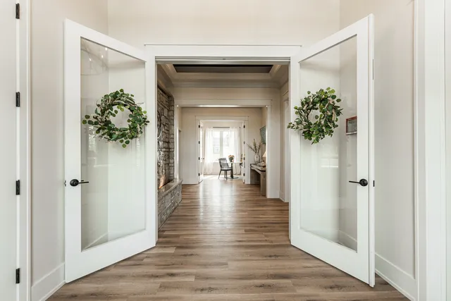 a view of a hallway with wooden floor and a livingroom