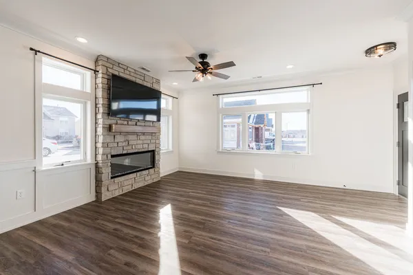 a view of an empty room with a window and wooden floor