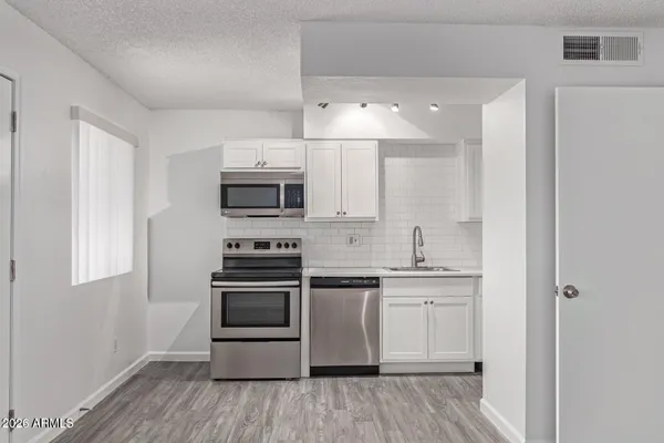 a kitchen with stainless steel appliances granite countertop a stove and a microwave