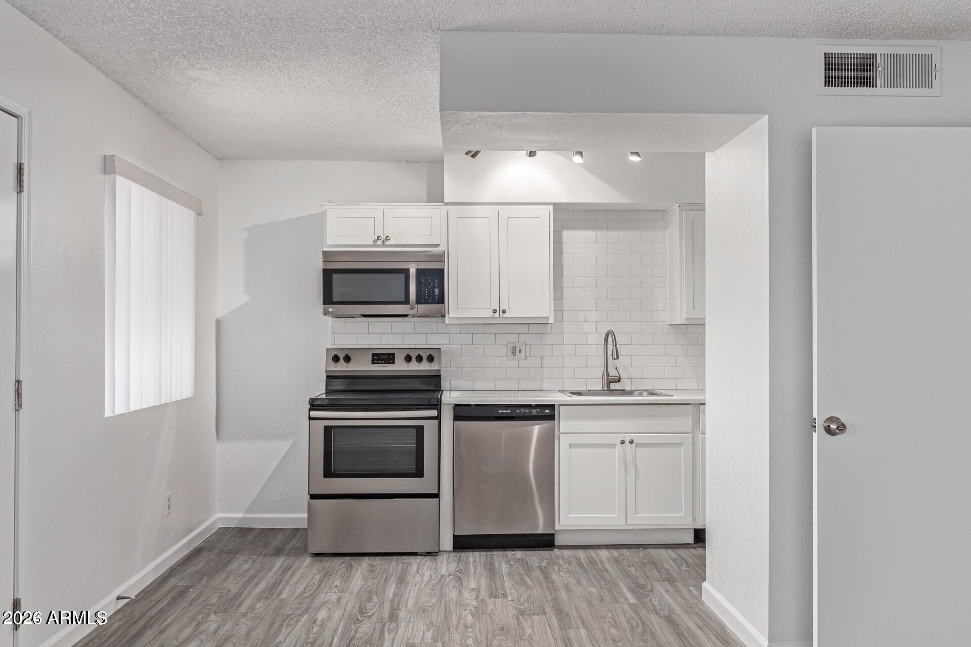 a kitchen with stainless steel appliances granite countertop a stove and a microwave