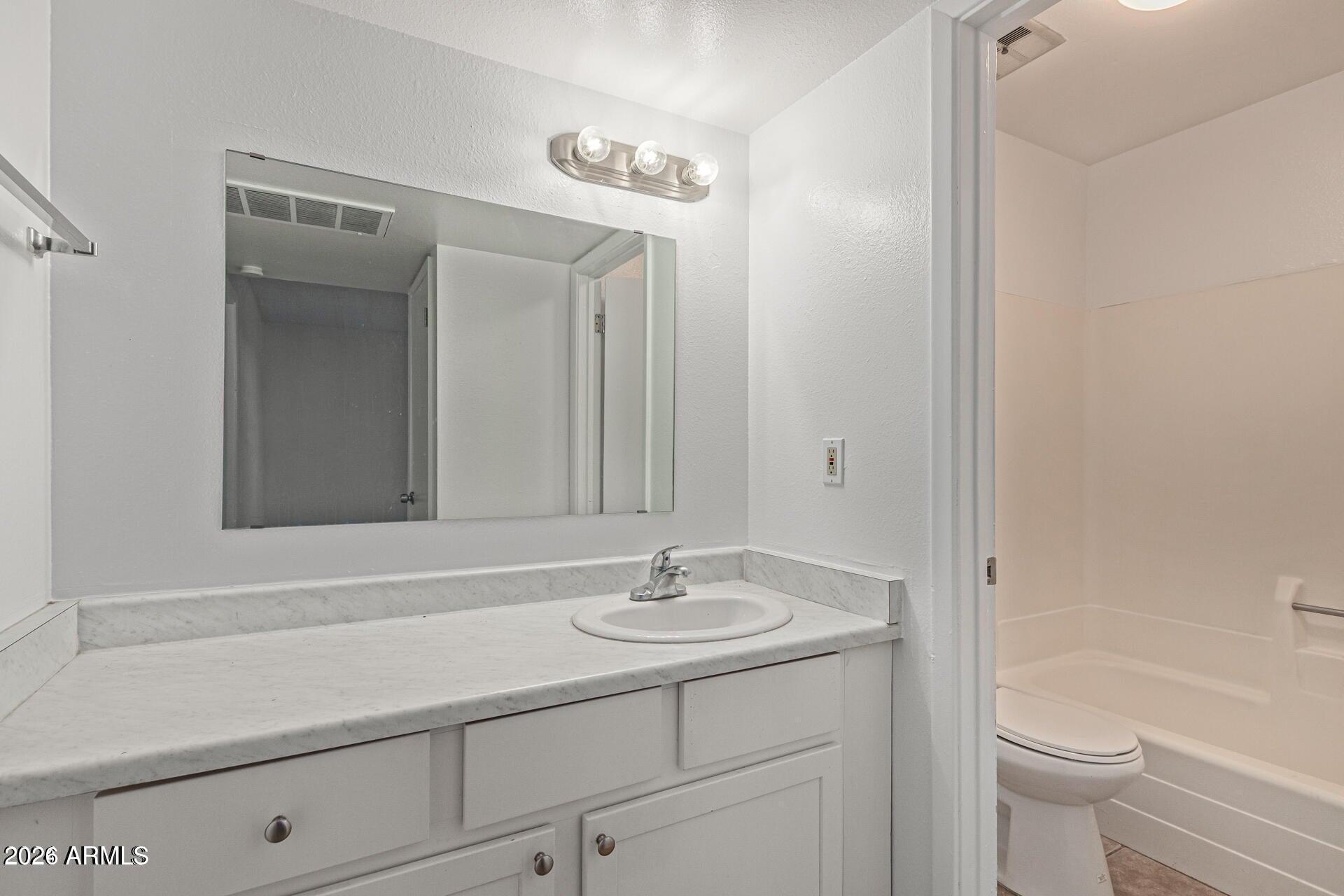 1029 South Wilson Street, Unit 14 Tempe, AZ 85281 - Photo 11 of 12 a bathroom with a sink a toilet and a mirror