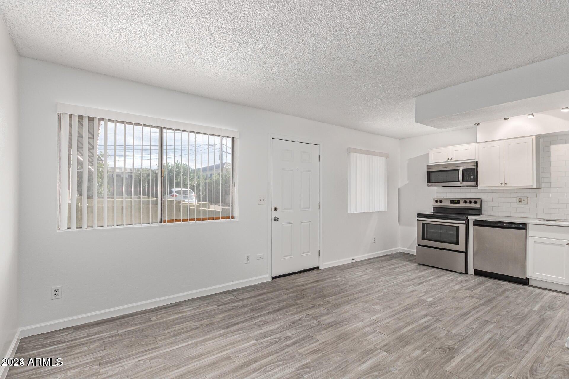 1029 South Wilson Street, Unit 14 Tempe, AZ 85281 - Photo 2 of 12 a kitchen with stainless steel appliances kitchen island granite countertop a stove and a refrigerator