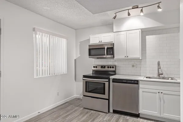 a kitchen with cabinets a window and stainless steel appliances