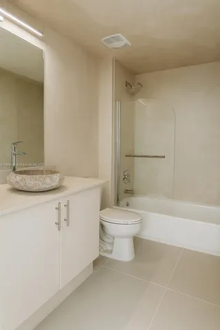 a bathroom with a white toilet sitting next to a bathroom sink and a shower