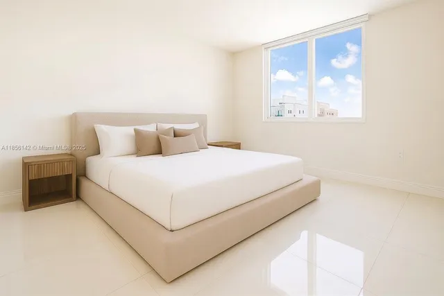 a large bed sitting in a bedroom next to a window