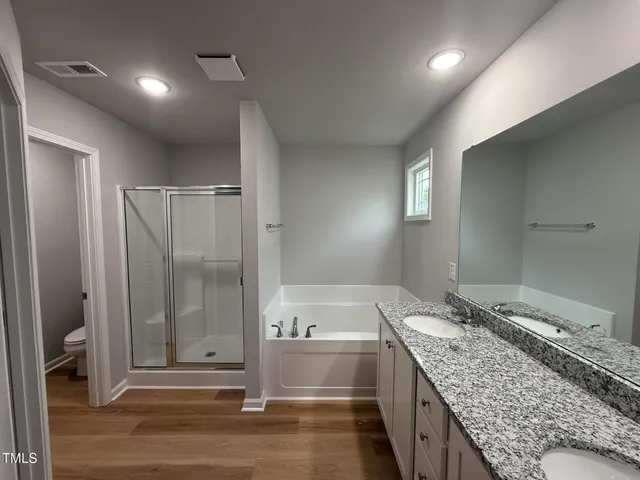 a bathroom with a granite countertop sink and mirror with bathtub