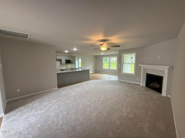 a view of an empty room with a fireplace and a window
