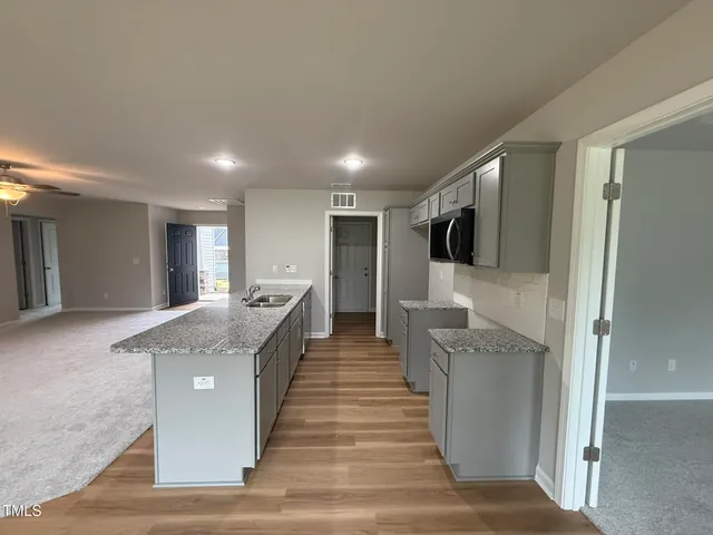 a large kitchen with a center island and stainless steel appliances