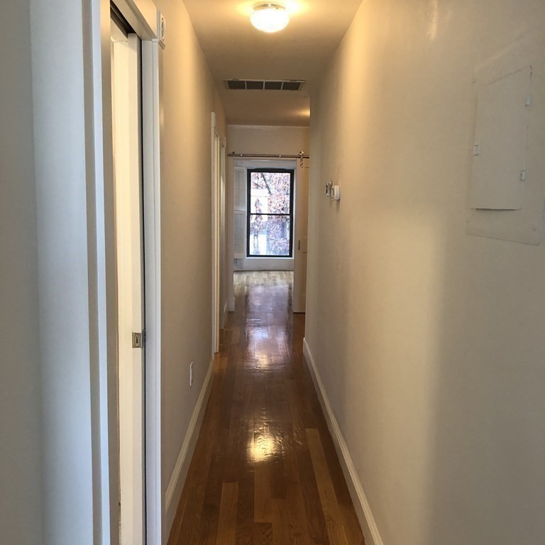29 Bay State Road, Unit 3 Boston, MA 02215 - Photo 10 of 22 a view of a hallway with wooden floor and a window