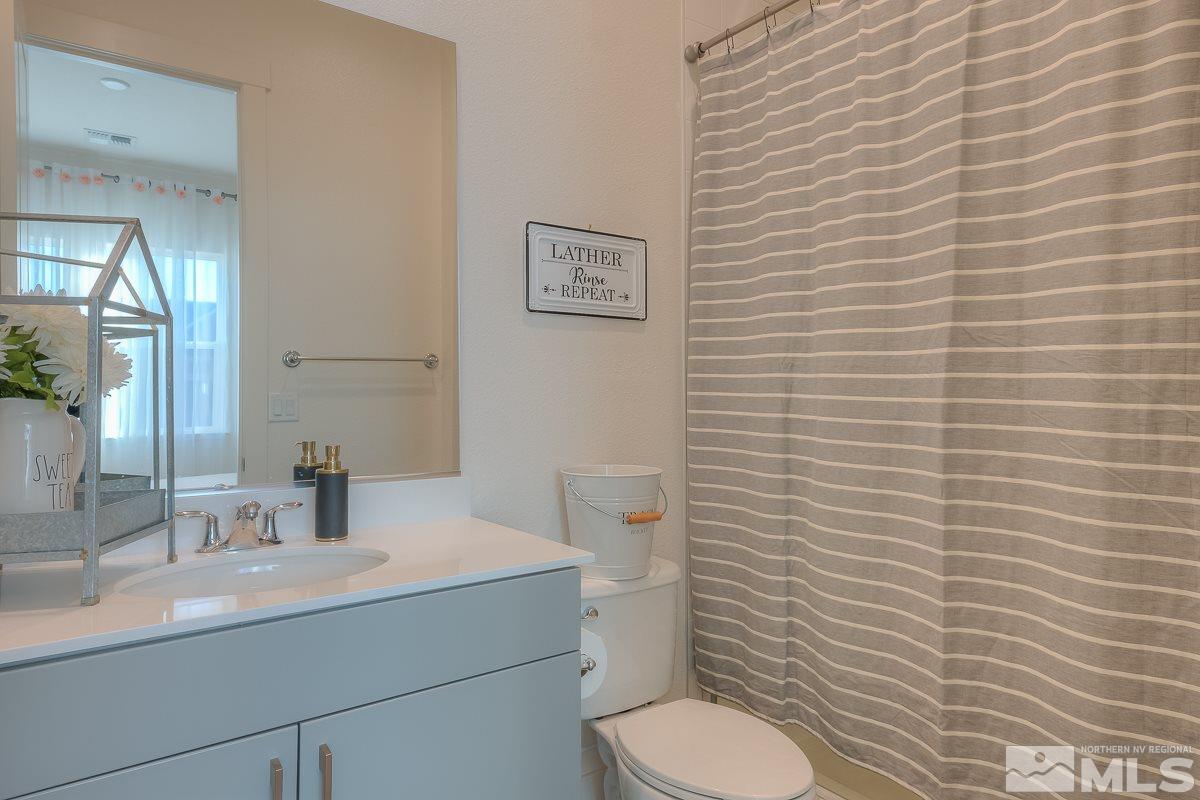 3018 Copper Stone Drive Reno, NV 89521 - Photo 11 of 29 a bathroom with a toilet a sink and mirror
