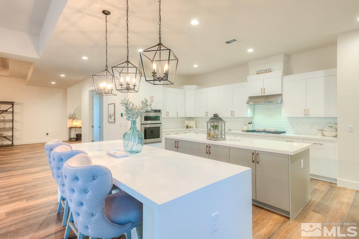 3018 Copper Stone Drive Reno, NV 89521 - Photo 19 of 29 a large kitchen with stainless steel appliances kitchen island granite countertop a sink a stove a dining table and chairs