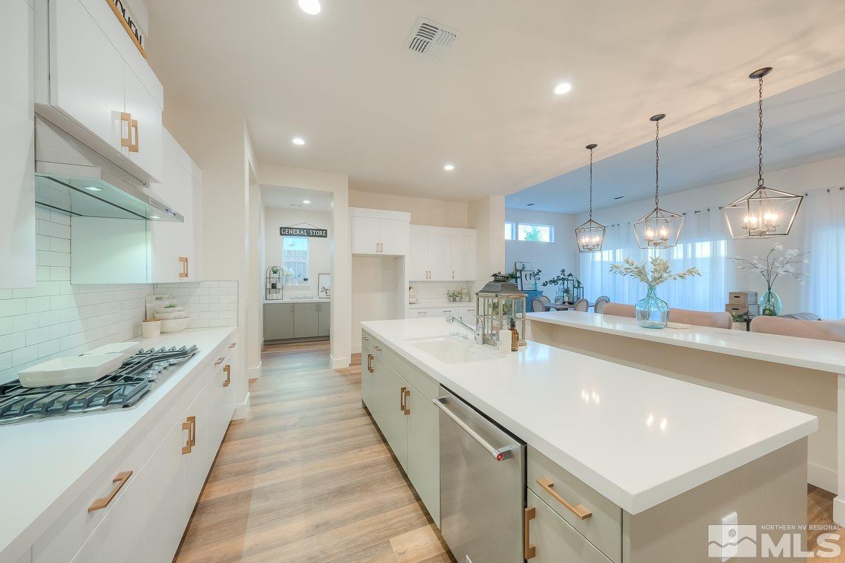 3018 Copper Stone Drive Reno, NV 89521 - Photo 22 of 29 a large white kitchen with a large counter top a sink stainless steel appliances and cabinets