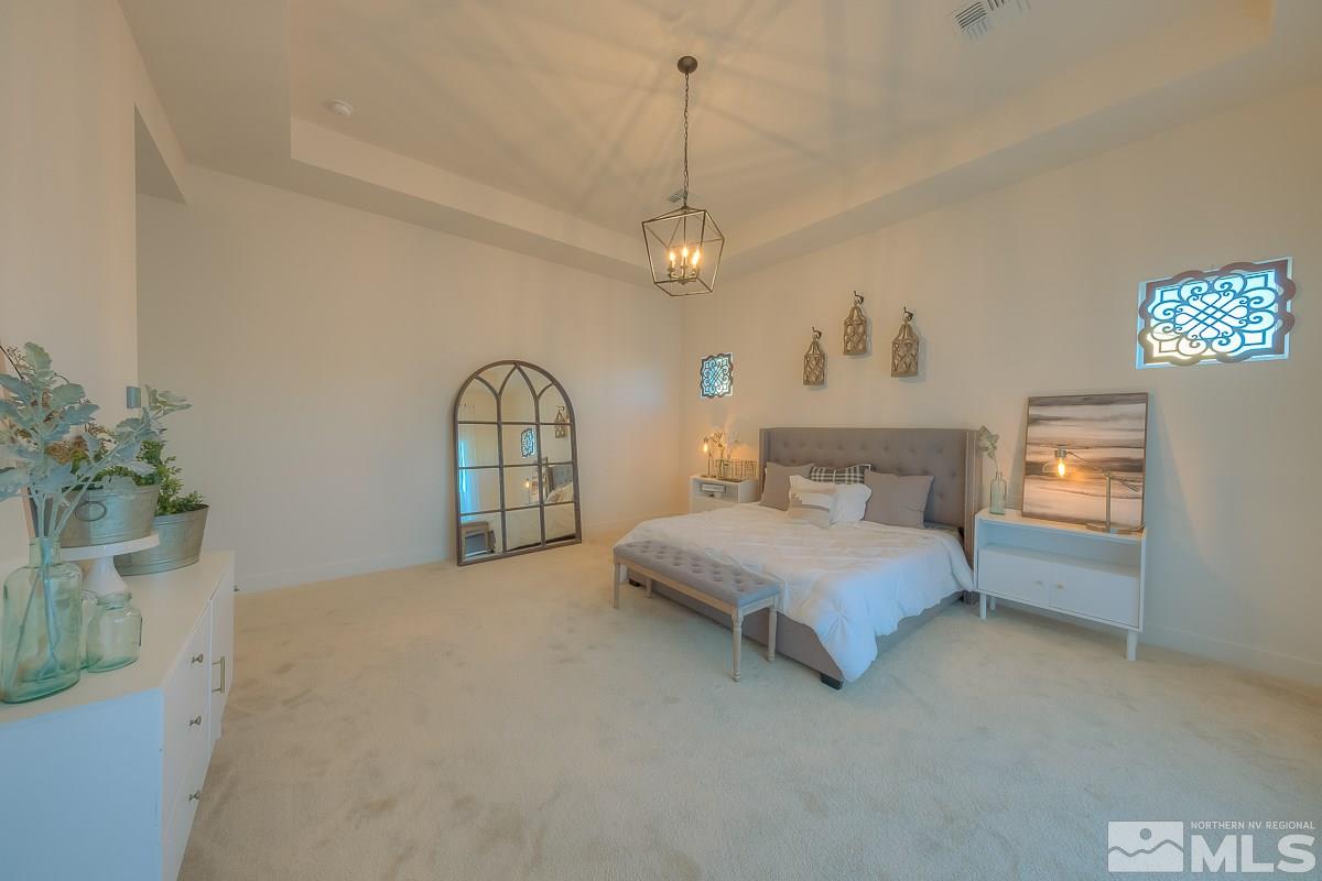 3018 Copper Stone Drive Reno, NV 89521 - Photo 5 of 29 a spacious bedroom with a bed chandelier and a window