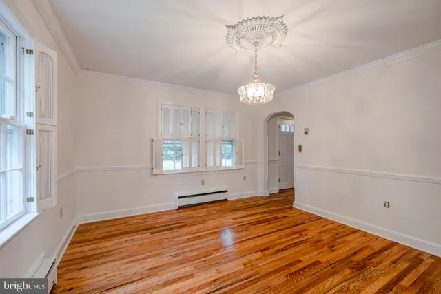 a view of a room with wooden floor and chandelier