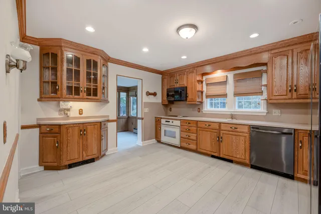 a large kitchen with stainless steel appliances granite countertop a stove sink and cabinets