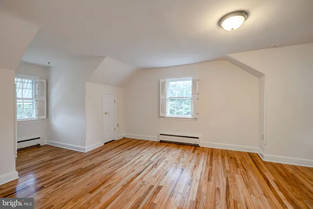 a view of empty room with window and wooden floor