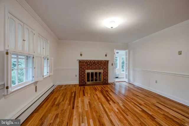 a view of empty room with wooden floor and fireplace
