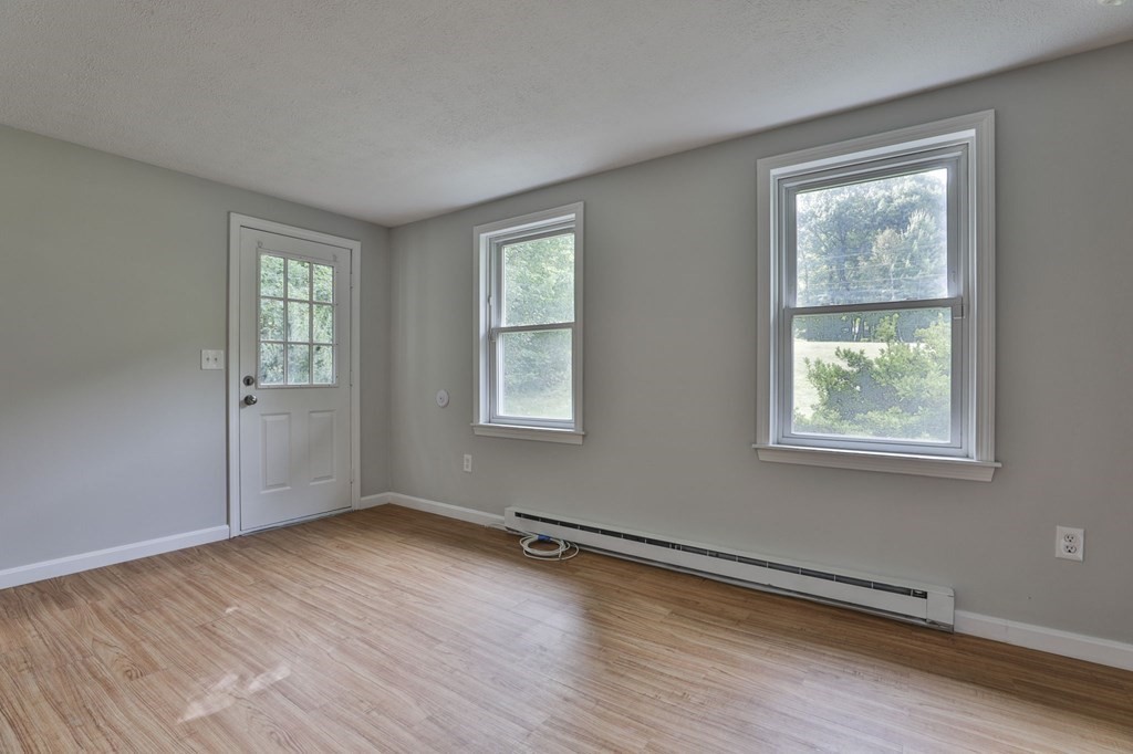 12 Al Derry Nh 03038, Unit R Derry, NH 03038 - Photo 8 of 23 a view of an empty room with wooden floor and a window